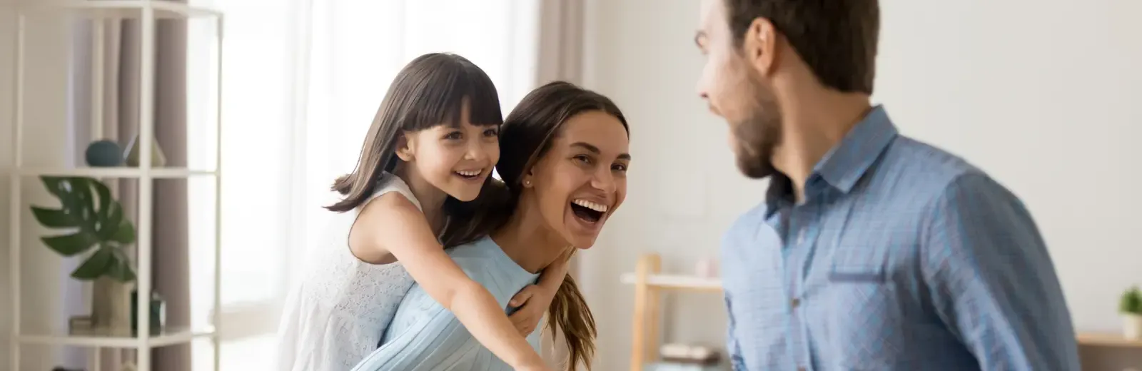 mom, dad, and daughter laughing and playing in pest free home